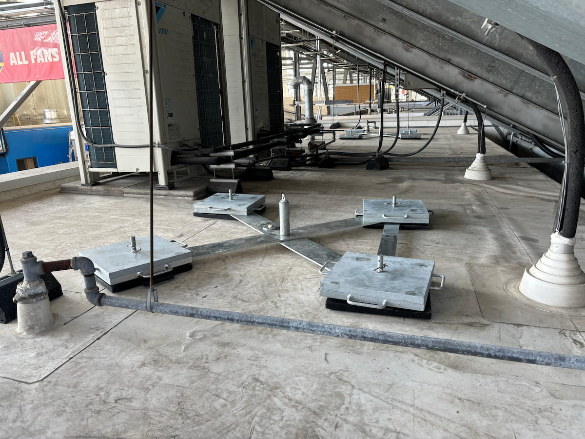 Système autoportant de ligne de vie horizontale et d’ancrage à contrepoids installé sous les structures d’acier du stade au BMO Field de Toronto, assurant un accès sécuritaire en toiture dans le cadre des préparatifs de la Coupe du Monde de la FIFA 2026